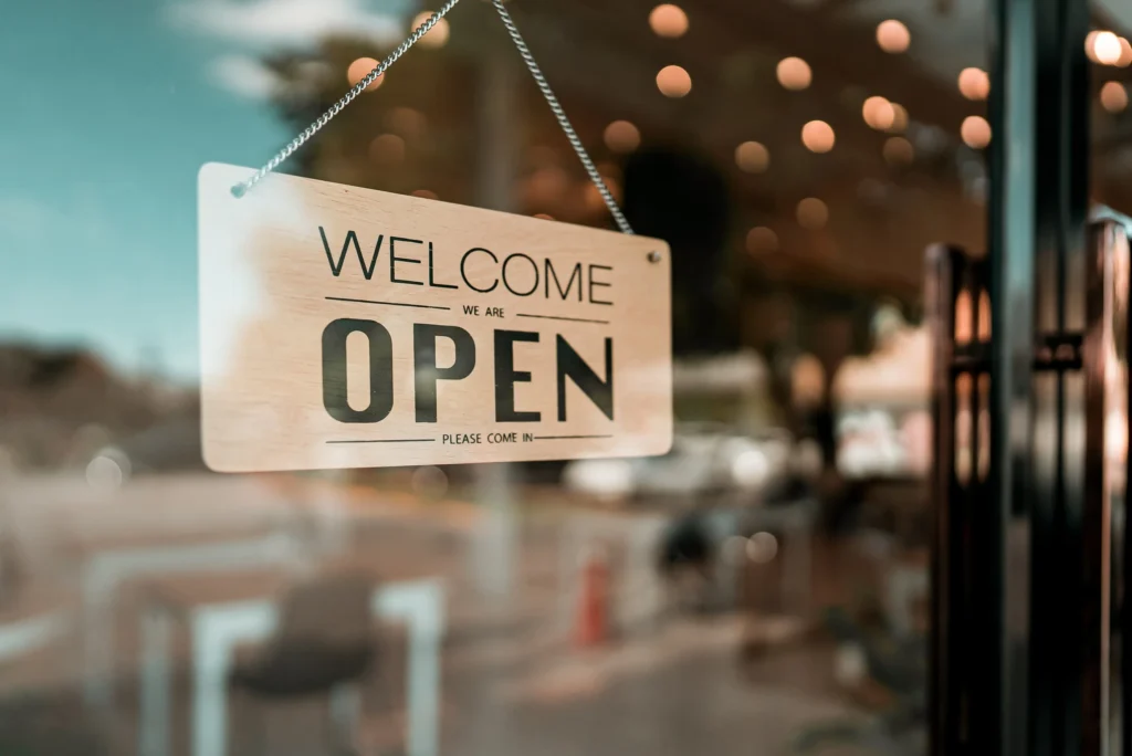 A sign hanging in the window of a restaurant.